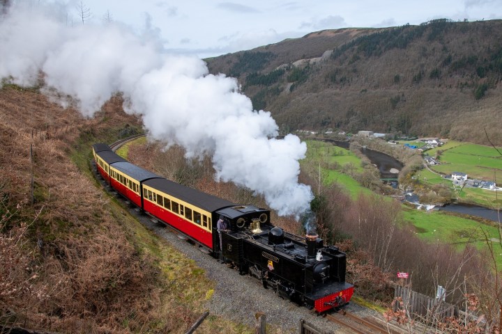 a steam engine riding on a train track with smoke coming out of it