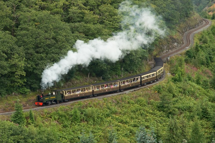 a large long train on a track with smoke coming out of it