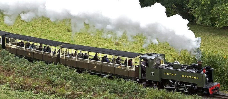 t1 a steam engine on a train track with smoke coming out of it