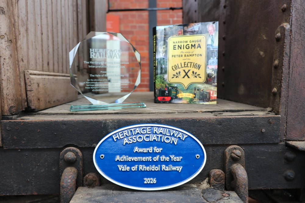 Trophies and book on a vintage railway carriage step with a Heritage Railway Association plaque.
