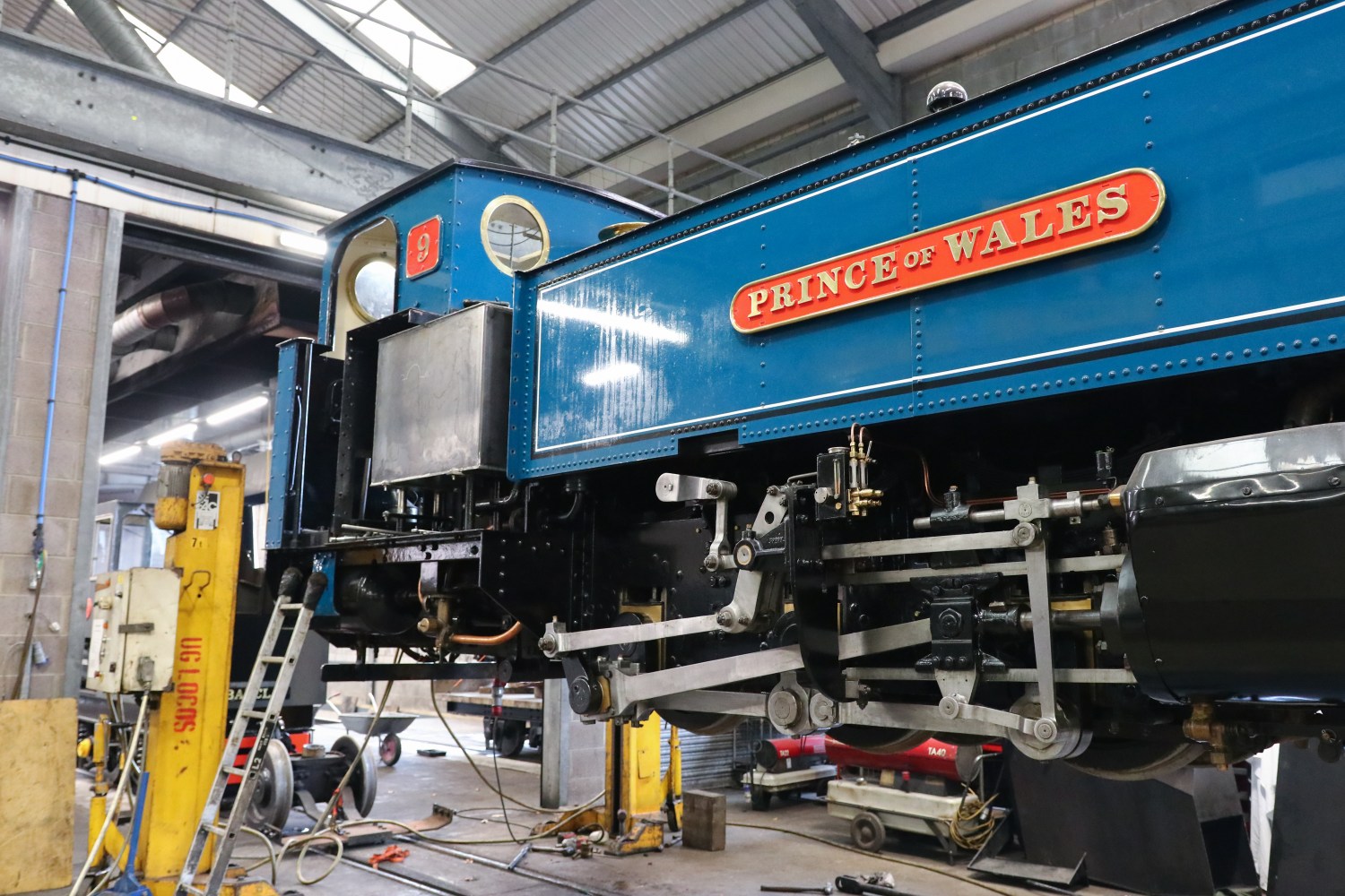 Blue steam locomotive named 'Prince of Wales' in a workshop.