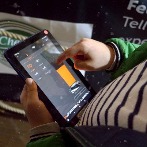 Person using a tablet with an app interface visible on screen.